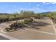 View of the secure entrance with stone features, desert landscaping, and a brick-paved road at 35556 N 87Th Pl, Scottsdale, AZ 85266