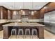 Modern kitchen featuring dark wood cabinetry, granite countertops, stainless steel appliances, and a large center island at 35556 N 87Th Pl, Scottsdale, AZ 85266