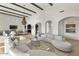 Spacious open-concept living room with beamed ceilings, arched doorways, and comfortable seating at 35556 N 87Th Pl, Scottsdale, AZ 85266