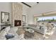 Bright and spacious living area with stone fireplace, high ceilings, and access to outdoor seating area at 35556 N 87Th Pl, Scottsdale, AZ 85266