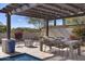Charming outdoor dining area under a pergola, featuring a cozy fire pit and ample seating for entertaining guests at 35556 N 87Th Pl, Scottsdale, AZ 85266