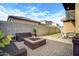 Well-maintained backyard with fire pit, outdoor seating, privacy wall, and minimal grassy area at 3890 E Perkinsville St, Gilbert, AZ 85295