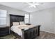 Comfortable bedroom with ceiling fan, decorative lighting, wood-look tile floors, and nightstand at 3890 E Perkinsville St, Gilbert, AZ 85295