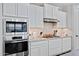 Bright kitchen with built-in stainless steel appliances and white cabinetry at 3890 E Perkinsville St, Gilbert, AZ 85295