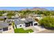Expansive aerial view of modern home with black and white exterior, manicured lawn, and mountain backdrop at 4246 E Mulberry Dr, Phoenix, AZ 85018