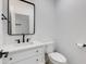 Bathroom with white vanity, marble countertop, dark hardware, toilet, and decorative black framed mirror at 4246 E Mulberry Dr, Phoenix, AZ 85018