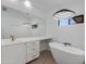 Bright bathroom featuring a soaking tub, floating vanity with gold hardware and modern lighting at 4246 E Mulberry Dr, Phoenix, AZ 85018
