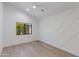 An empty bedroom with light wood floors, white walls, black trim windows, and a ceiling fan at 4246 E Mulberry Dr, Phoenix, AZ 85018