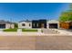 Modern home exterior boasts contrasting black and white accents, lush turf, and a paved driveway at 4246 E Mulberry Dr, Phoenix, AZ 85018