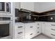 Close up kitchen view features stainless appliances, white cabinets, and sleek black backsplash at 4246 E Mulberry Dr, Phoenix, AZ 85018