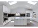 Bright, open kitchen features an expansive island, stainless steel appliances, skylights, and modern black backsplash at 4246 E Mulberry Dr, Phoenix, AZ 85018