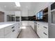 Modern kitchen with white cabinets, large island, stainless steel appliances, and eye-catching black backsplash at 4246 E Mulberry Dr, Phoenix, AZ 85018