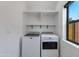 Bright laundry room features modern washer and dryer with sleek shelves and window providing natural light at 4246 E Mulberry Dr, Phoenix, AZ 85018