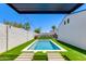 Stunning backyard pool featuring modern lounge chairs, pristine privacy walls, and lush artificial turf at 4246 E Mulberry Dr, Phoenix, AZ 85018