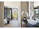 Modern bathroom with sleek fixtures, vessel sink, and large windows overlooking lush greenery at 4451 E Joshua Tree Ln, Paradise Valley, AZ 85253