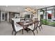 Chic dining room with modern light fixtures, a large table, and views of the outdoor landscape at 4451 E Joshua Tree Ln, Paradise Valley, AZ 85253