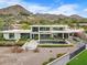Stunning modern home with a sleek design, swimming pool, and mountain views in the background at 4451 E Joshua Tree Ln, Paradise Valley, AZ 85253