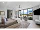 Bright main bedroom with ceiling fan, sitting area, and glass doors to the outdoors at 4451 E Joshua Tree Ln, Paradise Valley, AZ 85253