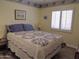 Cozy bedroom featuring a large bed with a floral patterned quilt and bright window at 4517 E Ute St, Phoenix, AZ 85044