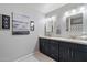 Stylish bathroom featuring dual sinks, modern fixtures, and gray cabinets with white countertops at 4569 E Lariat Ln, Phoenix, AZ 85050