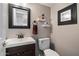 Compact half bathroom with a dark wood vanity, white sink, and modern fixtures at 4569 E Lariat Ln, Phoenix, AZ 85050