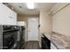Functional laundry room featuring a washer, dryer, utility sink, and extra storage space at 4569 E Lariat Ln, Phoenix, AZ 85050