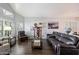 Comfortable living room with stylish furniture, wood floors, and natural light from large windows at 4569 E Lariat Ln, Phoenix, AZ 85050