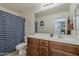 Well-lit bathroom features a modern vanity, spacious countertop, and a shower with a patterned curtain at 4607 S Venus --, Mesa, AZ 85212