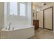 Bright bathroom with soaking tub under a window and separate shower with glass door at 4607 S Venus --, Mesa, AZ 85212