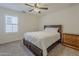 Neutral bedroom showcasing a plush queen-sized bed, a ceiling fan, and a bright window at 4607 S Venus --, Mesa, AZ 85212