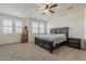 A bedroom with carpet and a large bed frame, accompanied by a ceiling fan and multiple windows at 4607 S Venus --, Mesa, AZ 85212