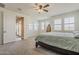 A bedroom with a ceiling fan and shuttered windows with access to the bathroom at 4607 S Venus --, Mesa, AZ 85212