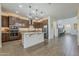 Open kitchen with a large island, pendant lighting, stainless appliances, and wood-look tile flooring at 4607 S Venus --, Mesa, AZ 85212