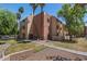 Condo exterior showing balconies, desert landscaping, and mature trees at 540 N May -- # 2148, Mesa, AZ 85201