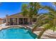 Lush backyard showcases a refreshing pool, hot tub, covered patio, and tropical landscaping at 7008 W Southgate Ave, Phoenix, AZ 85043