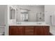 The ensuite bathroom offers a double vanity and is reflected in a large mirror at 7008 W Southgate Ave, Phoenix, AZ 85043