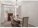 Dining room featuring modern chandelier, wood table, and seating for four at 7008 W Southgate Ave, Phoenix, AZ 85043