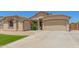 Beautiful house with desert landscaping, artificial grass, and two-car garage on a sunny day at 7008 W Southgate Ave, Phoenix, AZ 85043