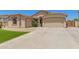 Beautiful house with desert landscaping, artificial grass, and two-car garage on a sunny day at 7008 W Southgate Ave, Phoenix, AZ 85043