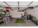 Spacious garage with overhead storage racks, shelving, work area, and exercise equipment at 7008 W Southgate Ave, Phoenix, AZ 85043