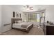 Comfortable main bedroom featuring a ceiling fan, dark wood accents, and ample natural light at 7008 W Southgate Ave, Phoenix, AZ 85043