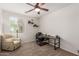 Bright office with a large window, comfortable recliner, and a functional desk setup at 7008 W Southgate Ave, Phoenix, AZ 85043