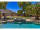 Inviting pool area features a hot tub with waterfall feature, palm trees, and ample seating at 7008 W Southgate Ave, Phoenix, AZ 85043