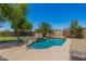 Beautiful backyard with a sparkling pool, spa, palm trees, and lush landscaping at 7008 W Southgate Ave, Phoenix, AZ 85043
