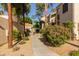 Manicured walkway featuring desert landscaping and mature trees leading to residential building at 7101 W Beardsley Rd # 422, Glendale, AZ 85308