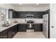Modern kitchen with stainless steel appliances, quartz countertops, and dark wood cabinets at 7227 S 13Th Way, Phoenix, AZ 85042
