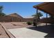 View of backyard with concrete patio, desert landscaping, and view of neighboring houses at 7425 N 69Th Ln, Glendale, AZ 85303