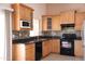 Well-appointed kitchen with black appliances, granite countertops, and light wood cabinetry at 7425 N 69Th Ln, Glendale, AZ 85303