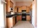 Well-lit kitchen with black appliances, granite countertops, and light wood cabinetry at 7425 N 69Th Ln, Glendale, AZ 85303