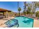 Community pool with a hot tub is surrounded by palm trees and greenery at 7557 N Dreamy Draw Dr # 139, Phoenix, AZ 85020